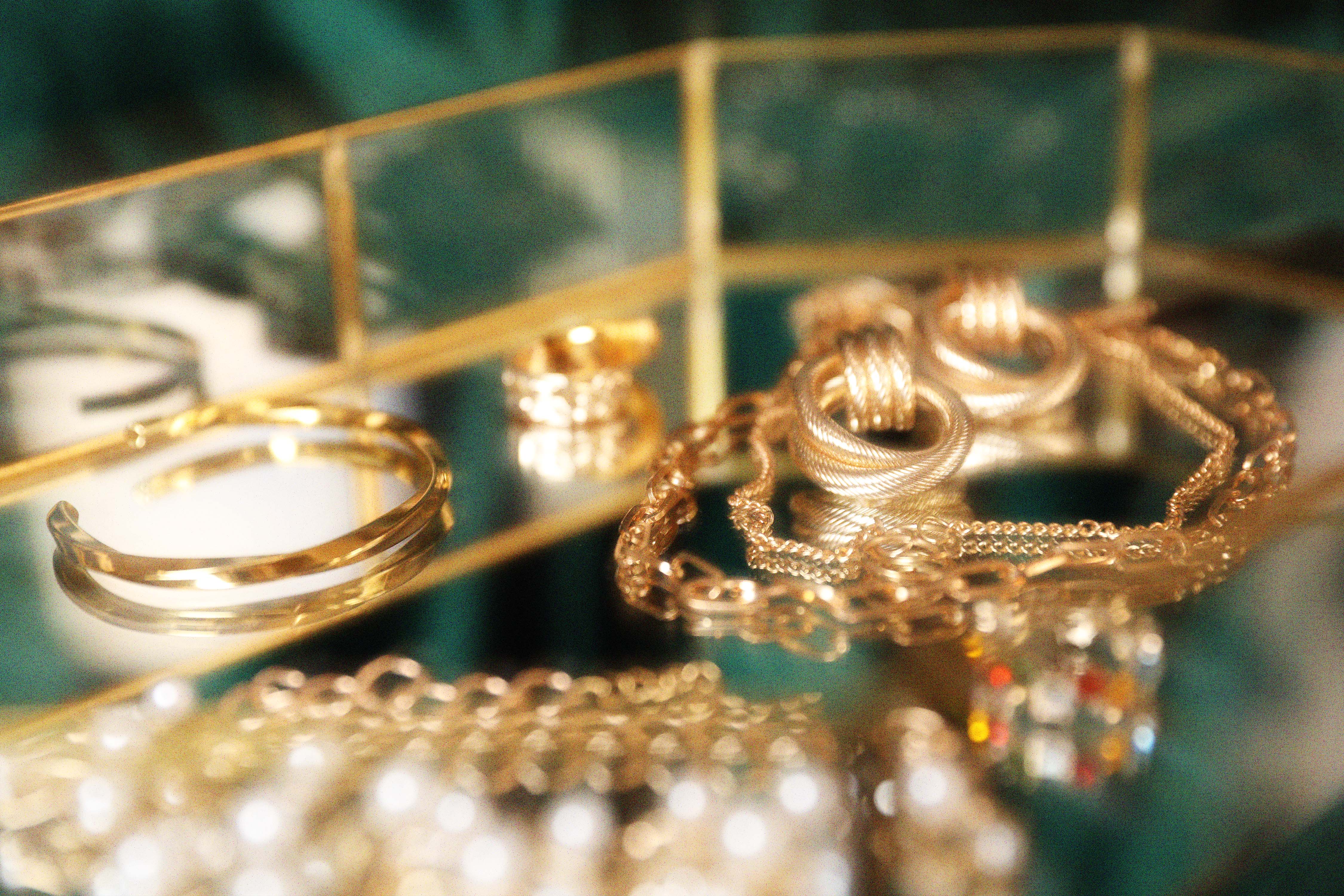 Gold jewelry on a mirrored tray
