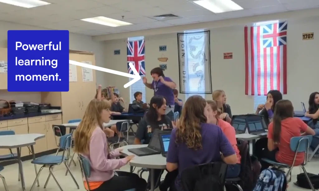 A student jumps out of his chair in excitement
