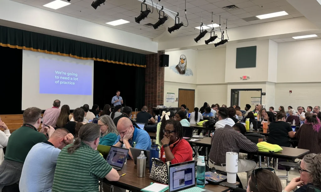 Adam Sparks presenting to a cafeteria full of teachers