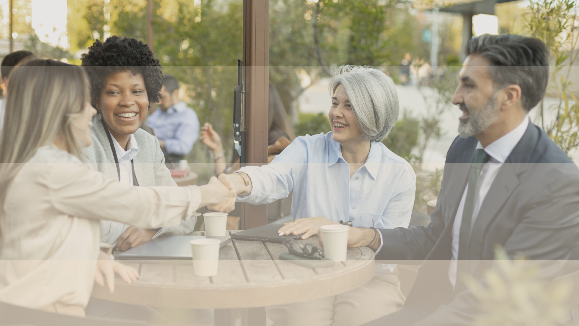 A team handshake at an outdoor table