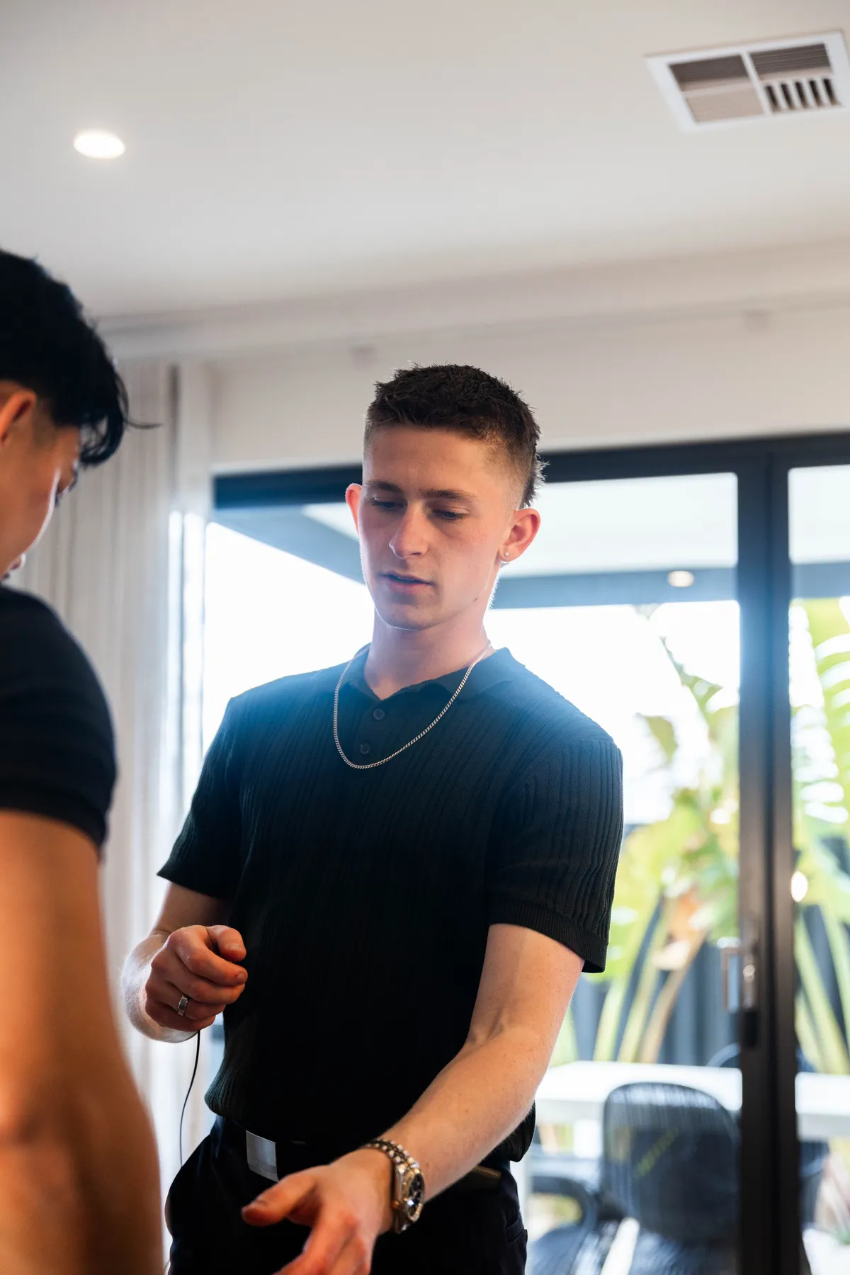 Keoni Upton talking with someone before a shoot in a Perth home.