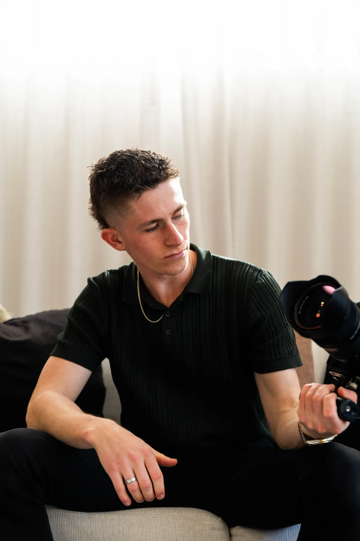 Keoni Upton looking down while holding a cinema camera on a Perth shoot.