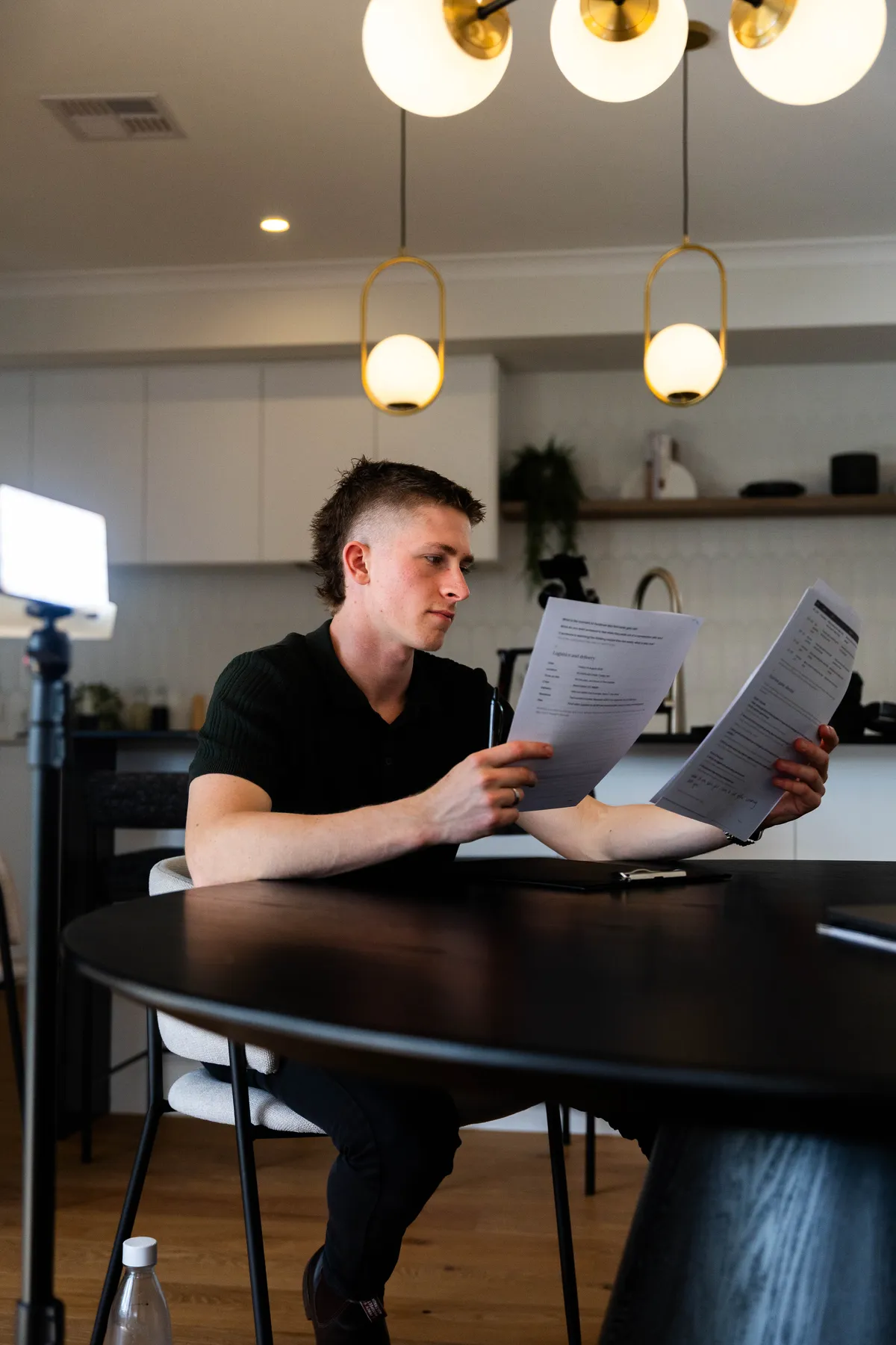 Keoni Upton reading a run sheet beside a light on a Perth shoot.