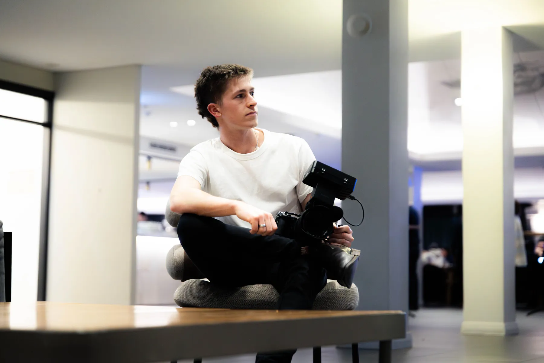 Keoni Upton sitting with a cinema camera during a Perth personal-brand shoot.