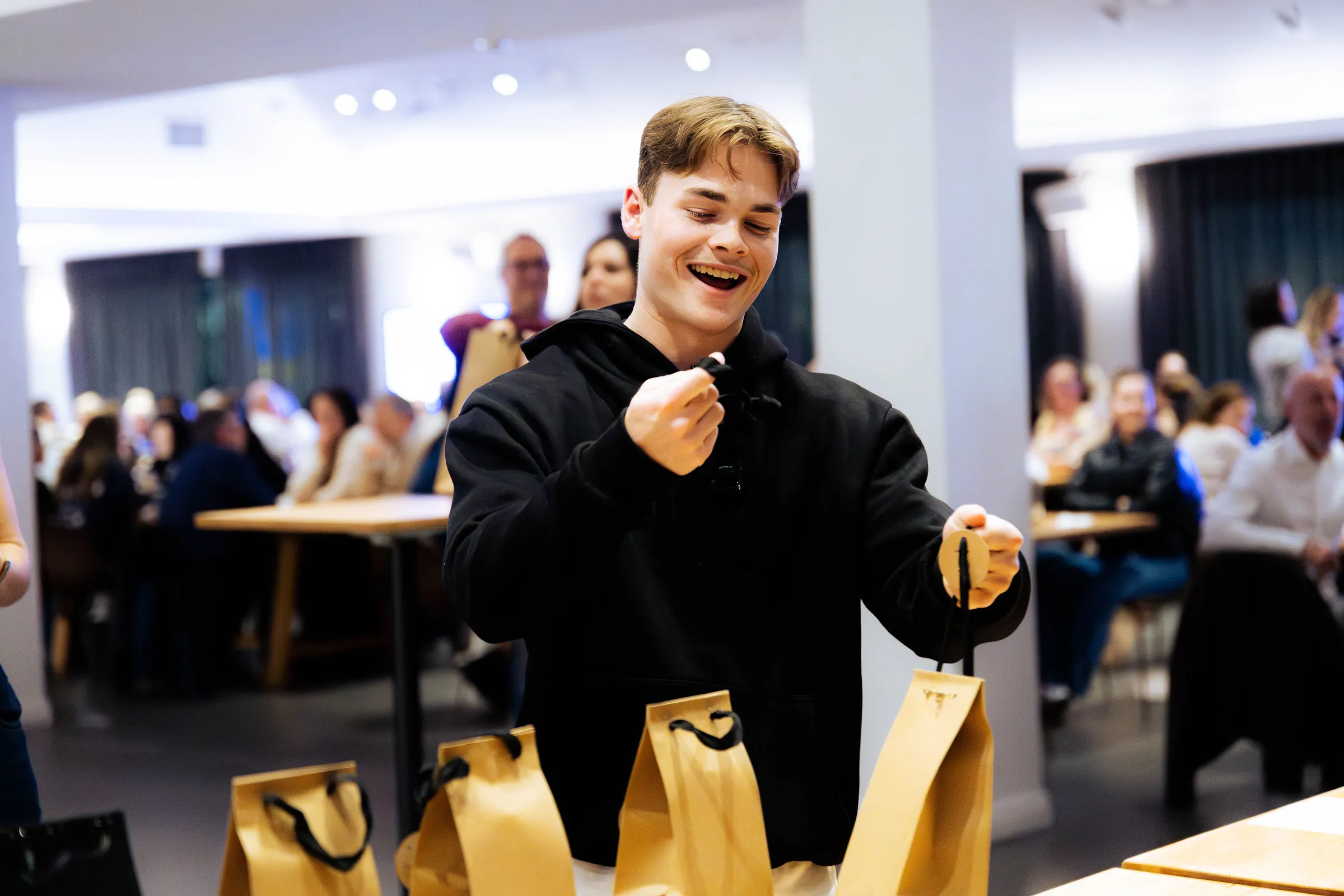 A guest in a black hoodie looking through gift bags at the Armed For Life quiz night at The Hall, The Camfield, Burswood.