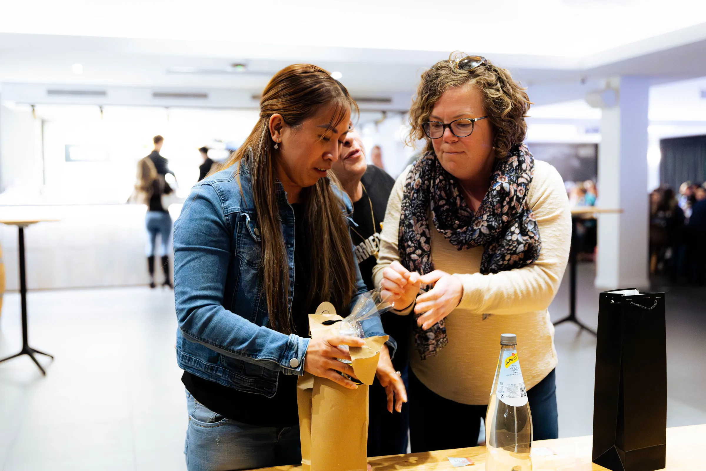 Two guests looking into a gift bag at the Armed For Life quiz night at The Hall, The Camfield, Burswood.