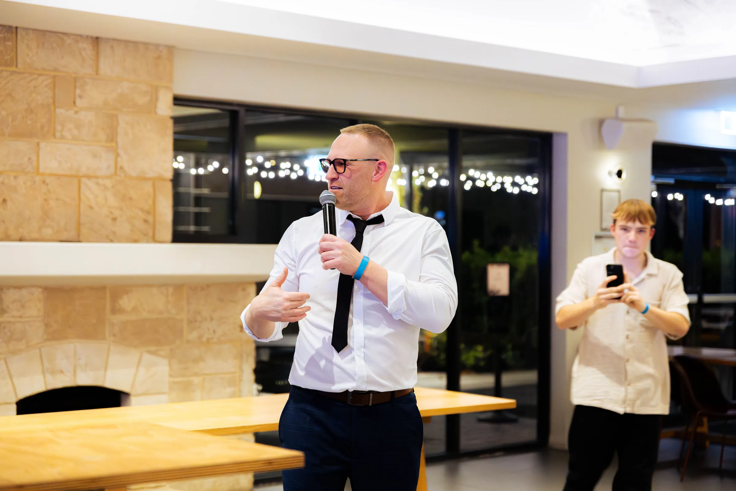 A guest speaking into a microphone at the Armed For Life quiz night at The Hall, The Camfield, Burswood.
