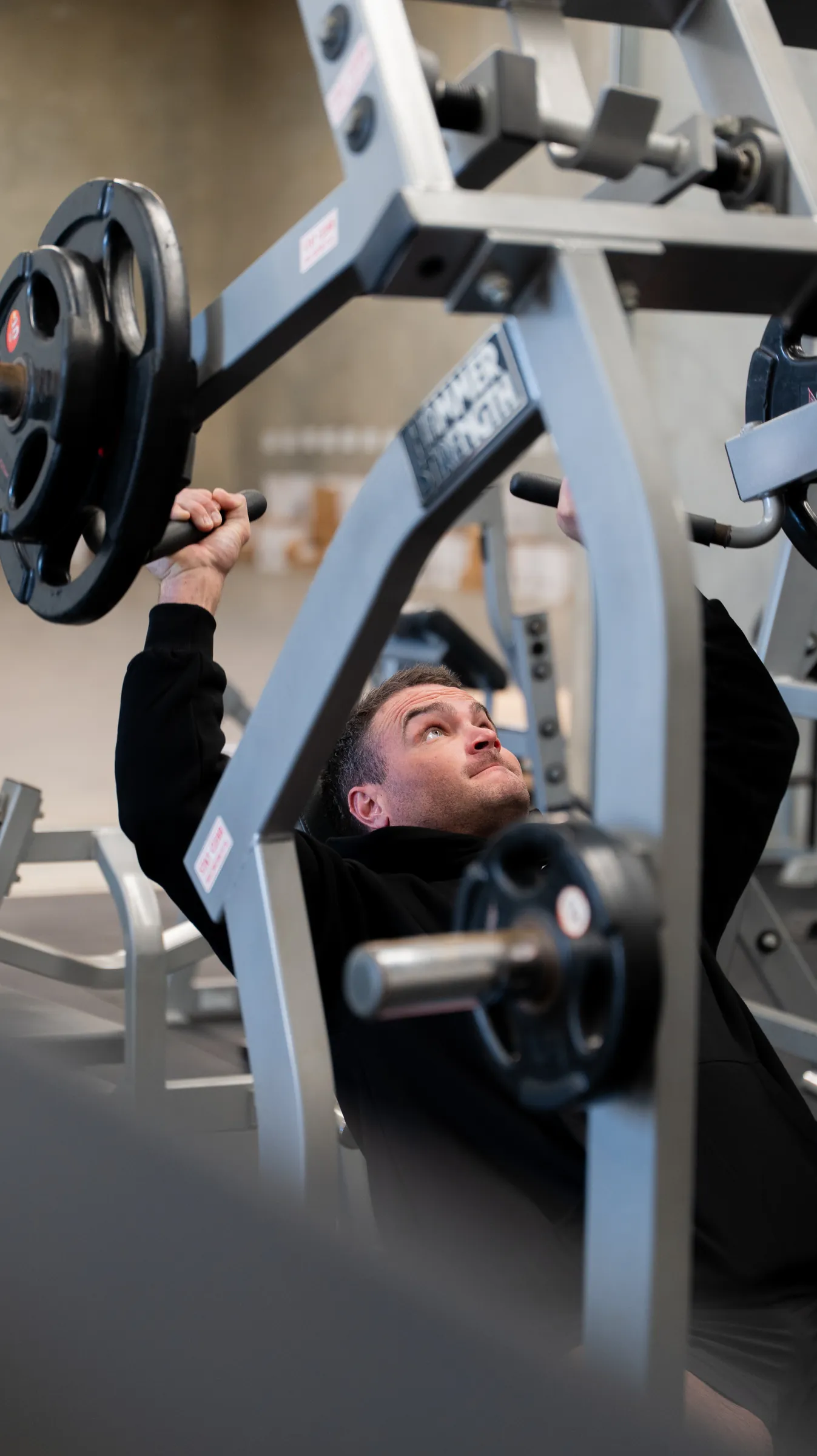 A man training on a chest press in a Perth gym, photographed by Growth Concept Media.