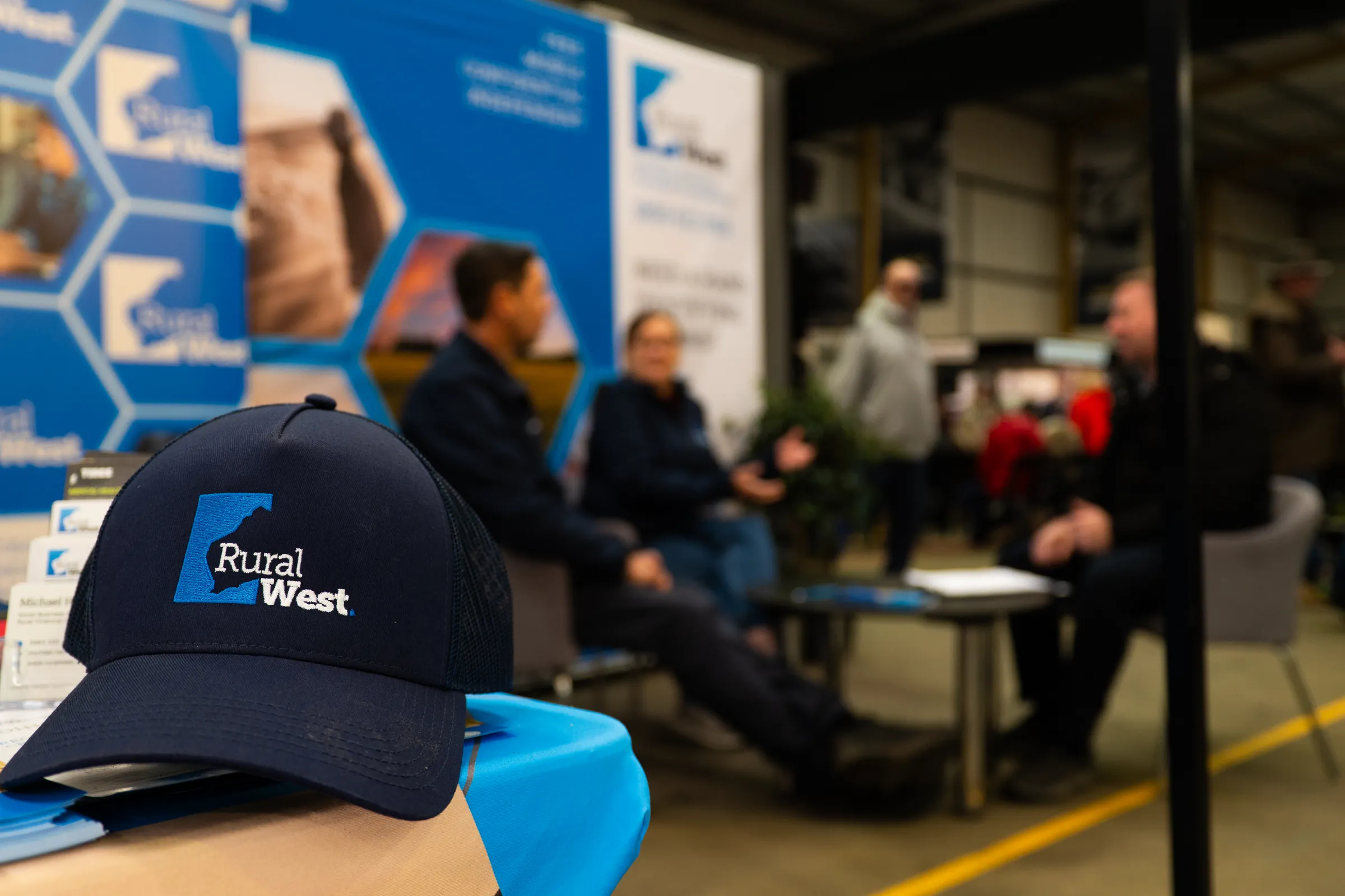 People talking at a Rural West stand, photographed by Growth Concept Media.