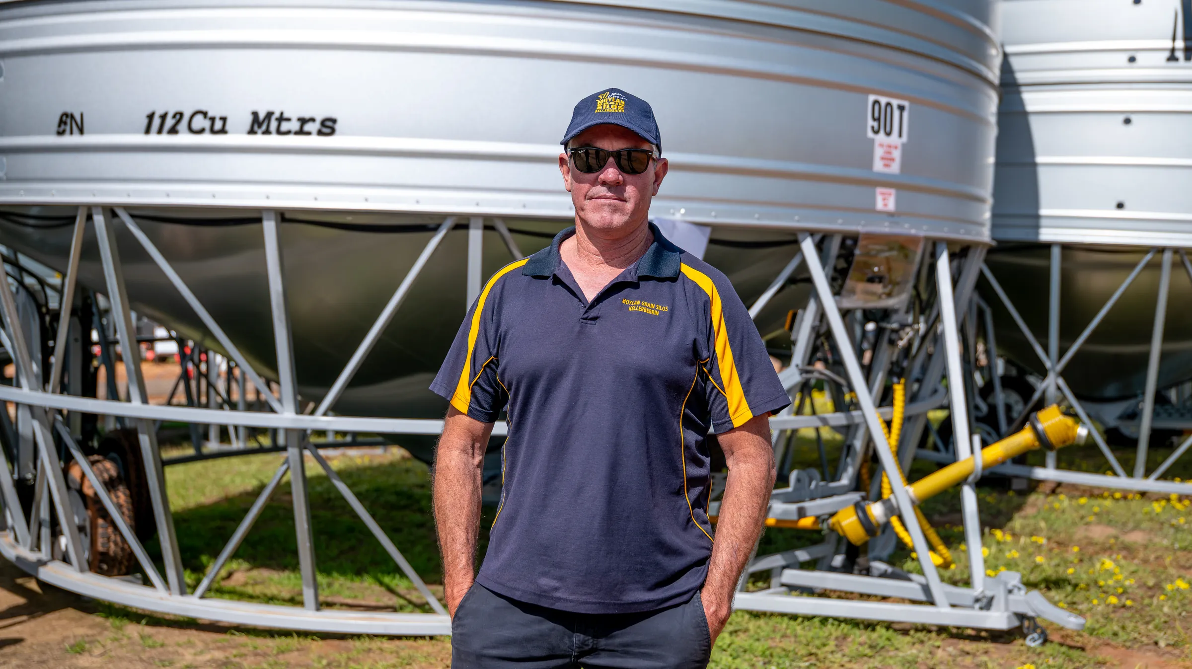 A man standing in front of grain silos, photographed by Growth Concept Media.