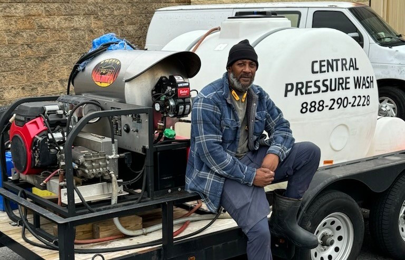 Arthur Gray, Jr., owner of Central Pressure Wash, seated on his hot-water pressure washing trailer rig in Atlanta