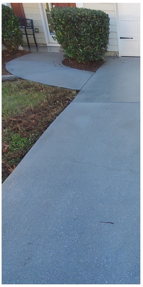The same concrete walkway evenly clean after surface cleaning