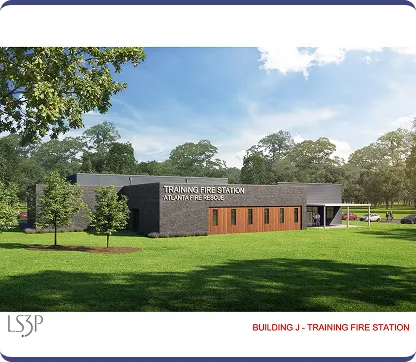 Modern single-story training fire station building with a brick and wood facade, surrounded by green grass and trees under a blue sky.