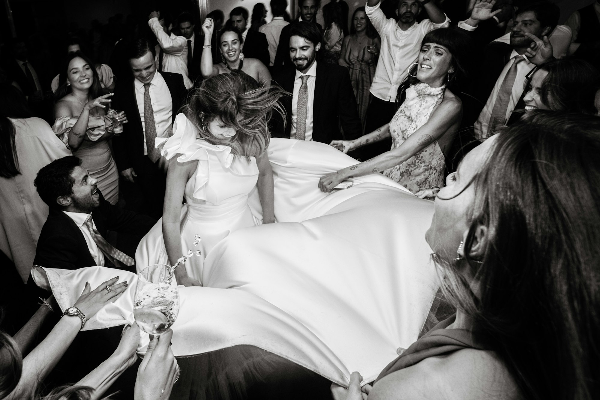 Guests lifting the bride in the air at a wedding celebration