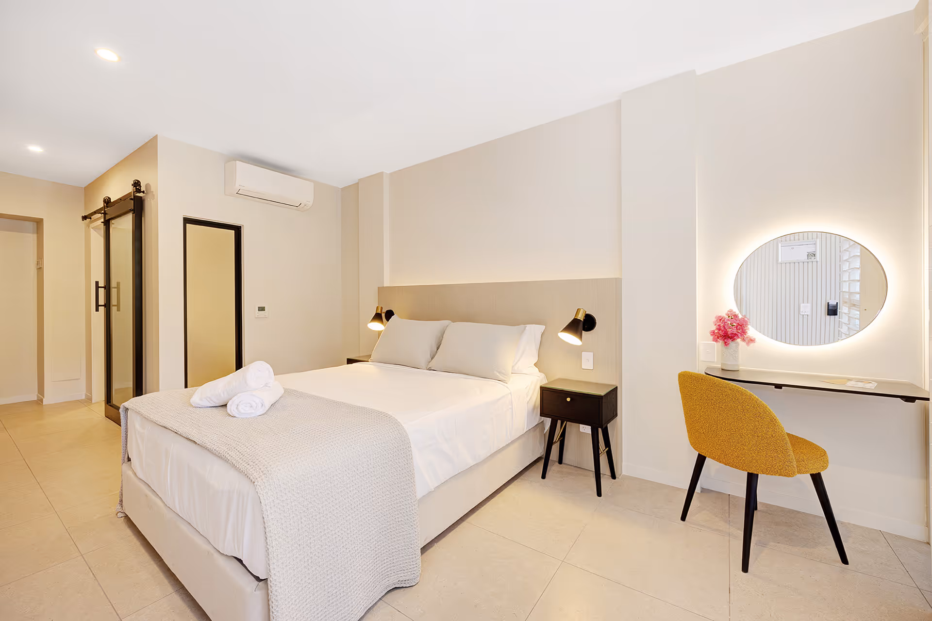 The Garden Queen Room, with a queen bed, round mirror and desk.