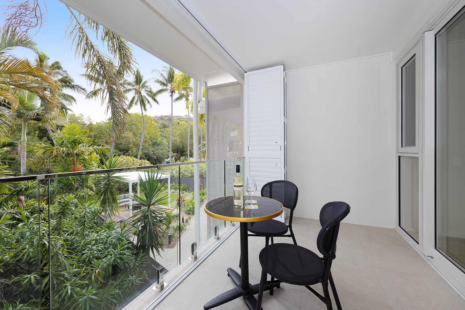 The balcony of the Superior Palm Room, with a table and chairs among the palms.
