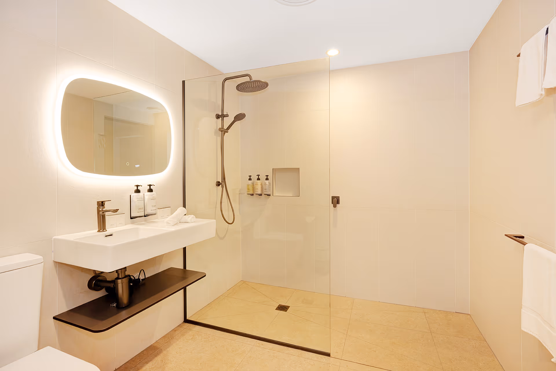 The Superior Palm Room bathroom, with a walk-in shower and backlit mirror.
