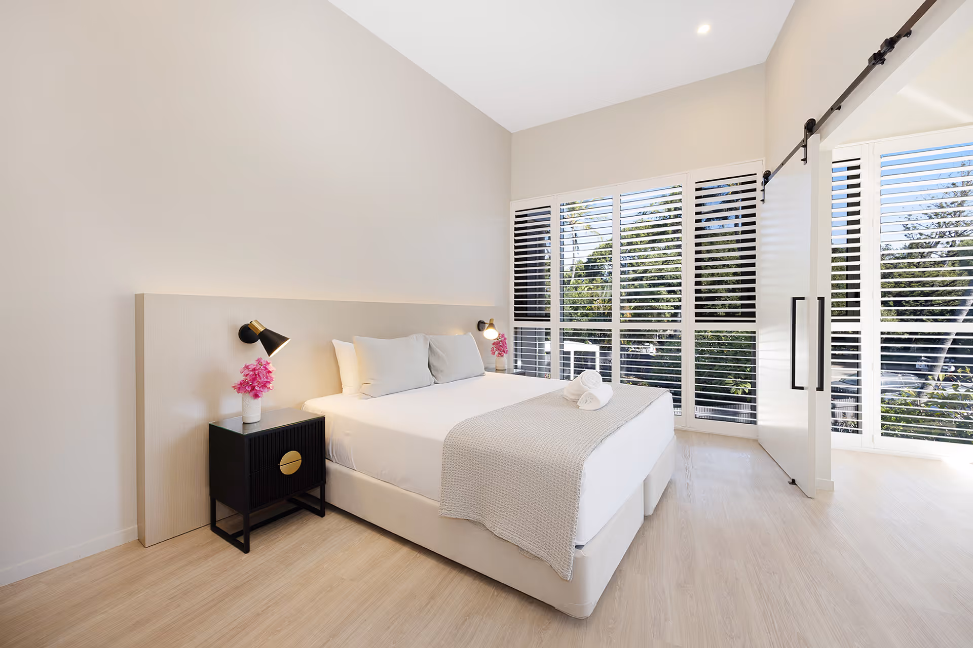 The king bed in the Executive Suite, with louvred doors opening to the garden.
