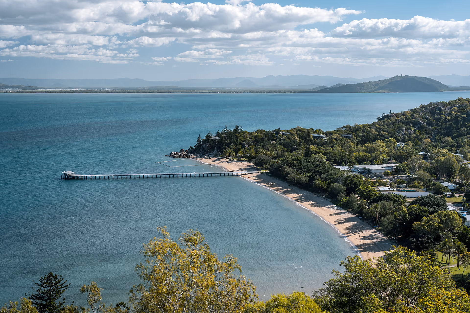 Picnic Bay curving away below the hillside, the jetty reaching into the sea.
