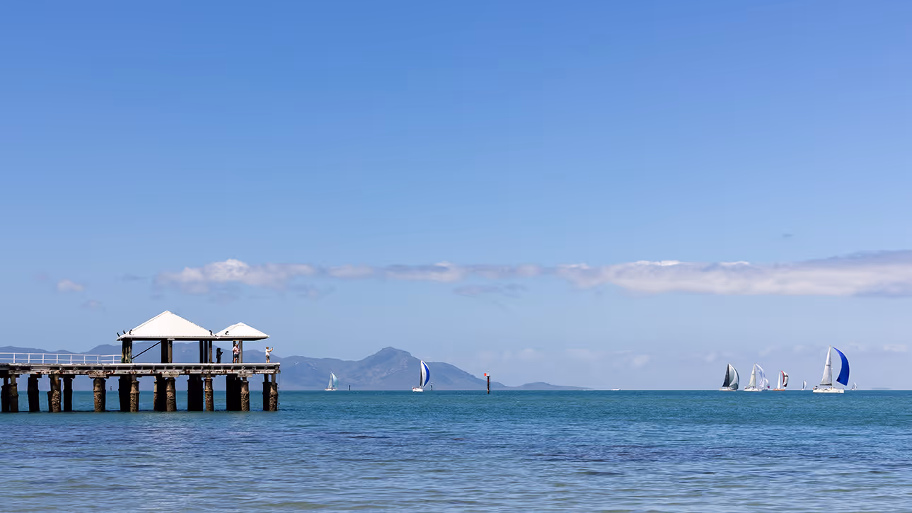 Yachts on the water off Picnic Bay, with the mainland ranges on the horizon.