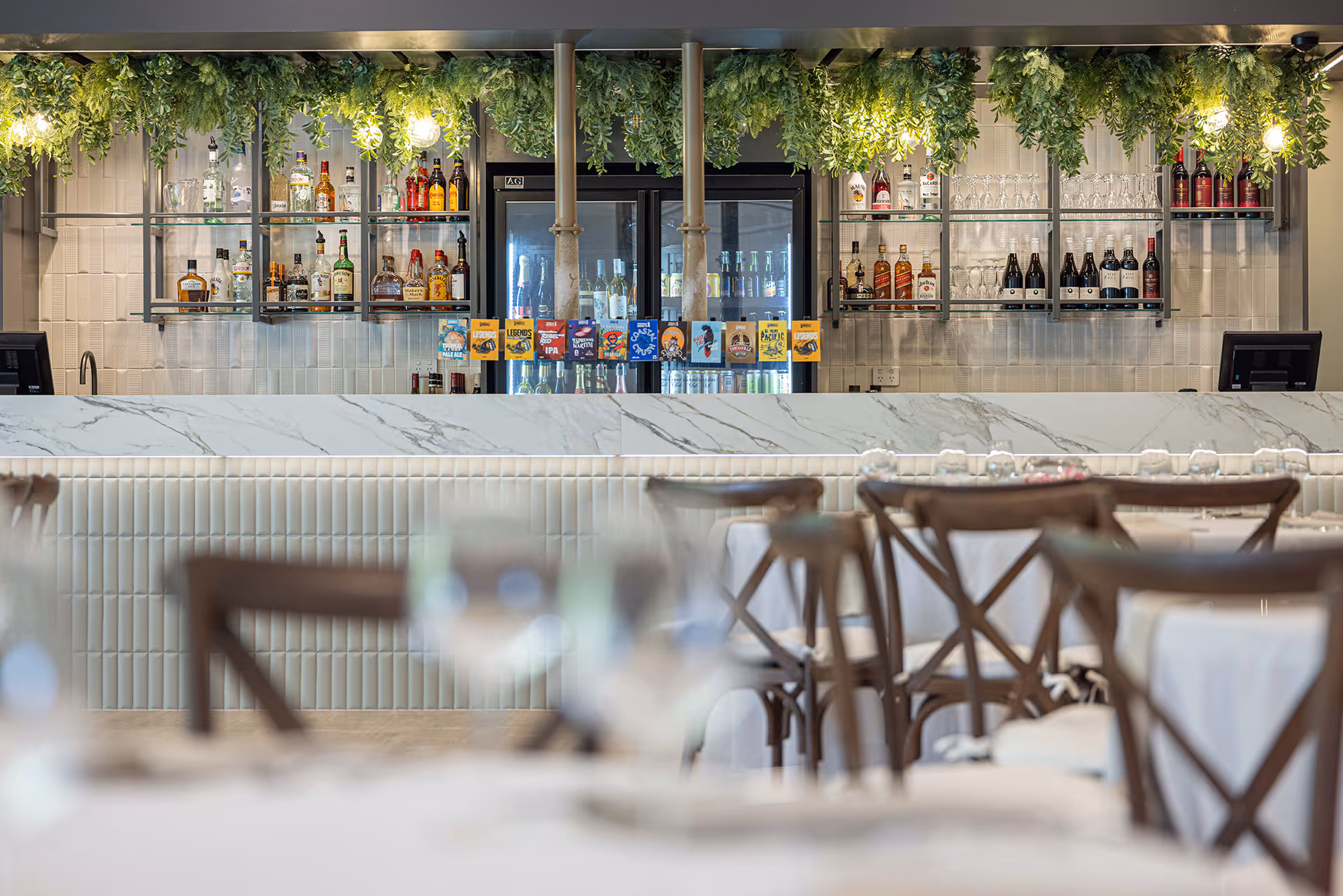 The bar at Picnic Bay Hotel, with cross-back stools and trailing greenery.