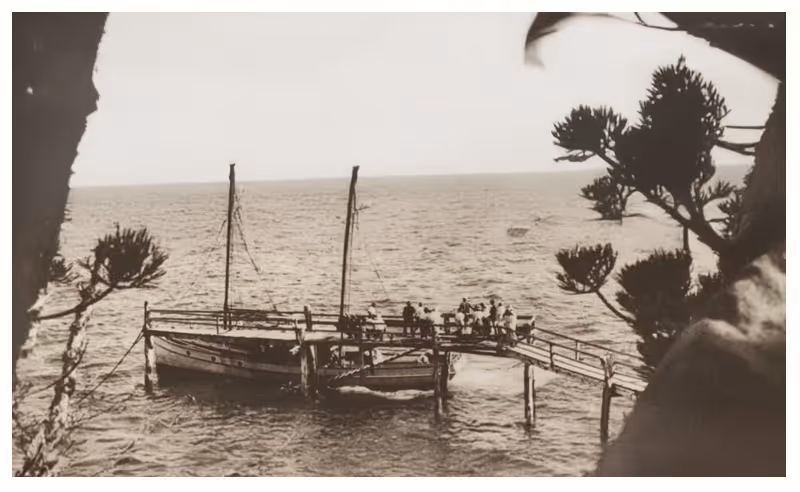 An archival photograph of passengers boarding a boat at the Picnic Bay jetty.