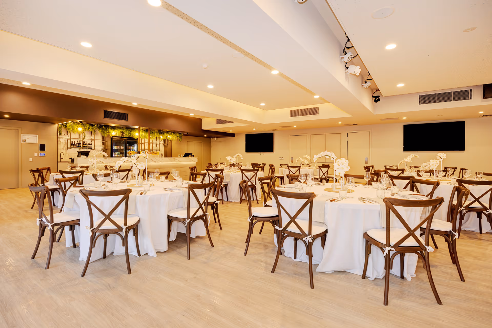 The Magnetic Room set for a seated function with round tables and cross-back chairs.