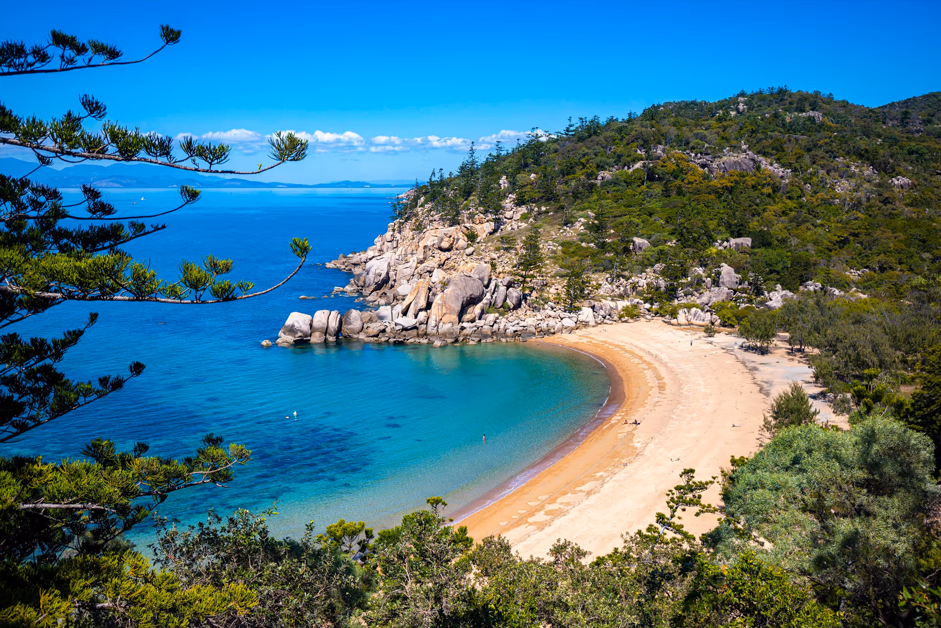 A sheltered Magnetic Island bay ringed by granite boulders and clear turquoise water.