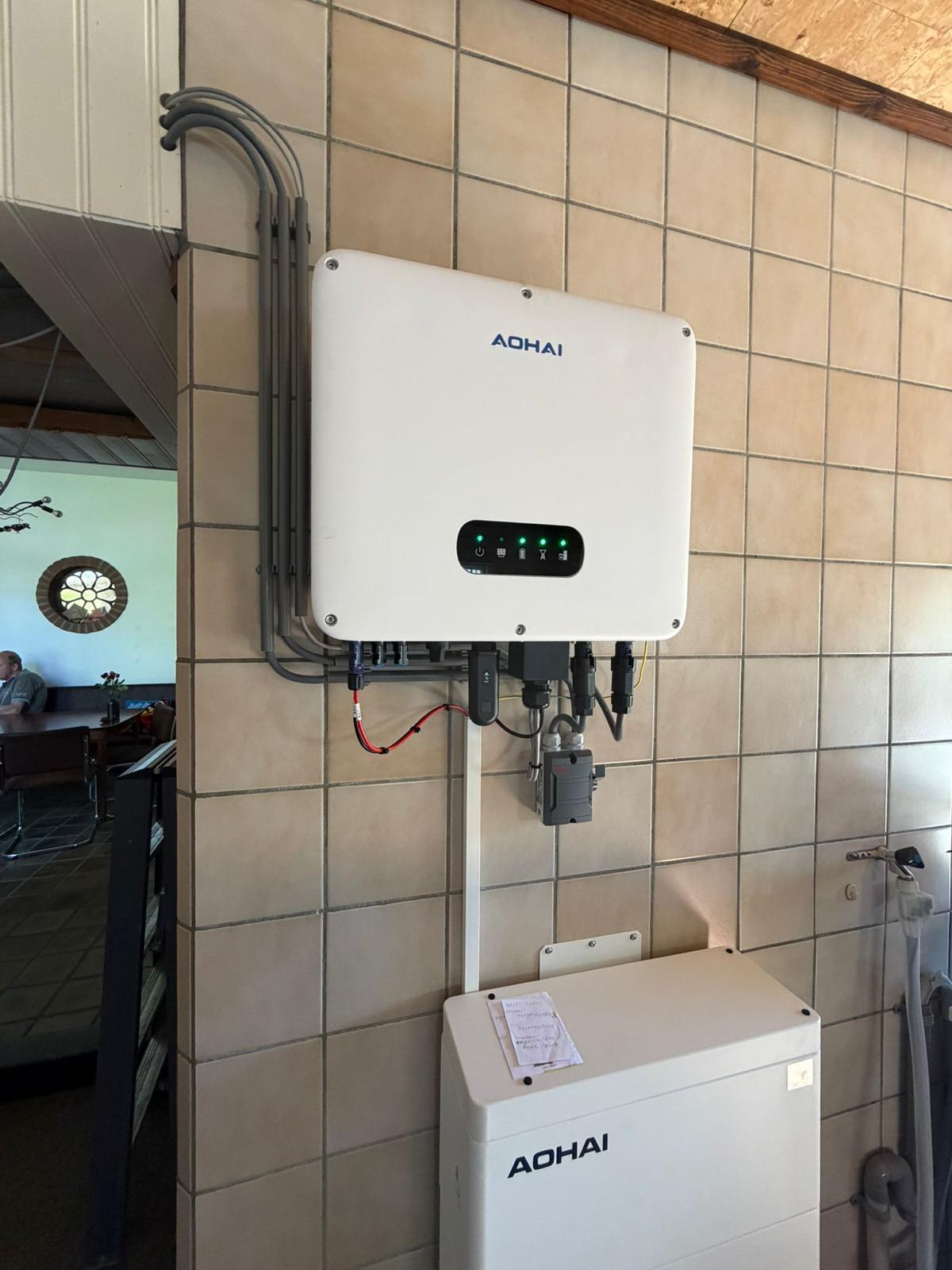 Thuisbatterij met omvormer aan de wand in een woning