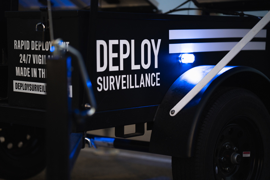 close up of security trailer body with flashing blue light in parking lot at night for protection
