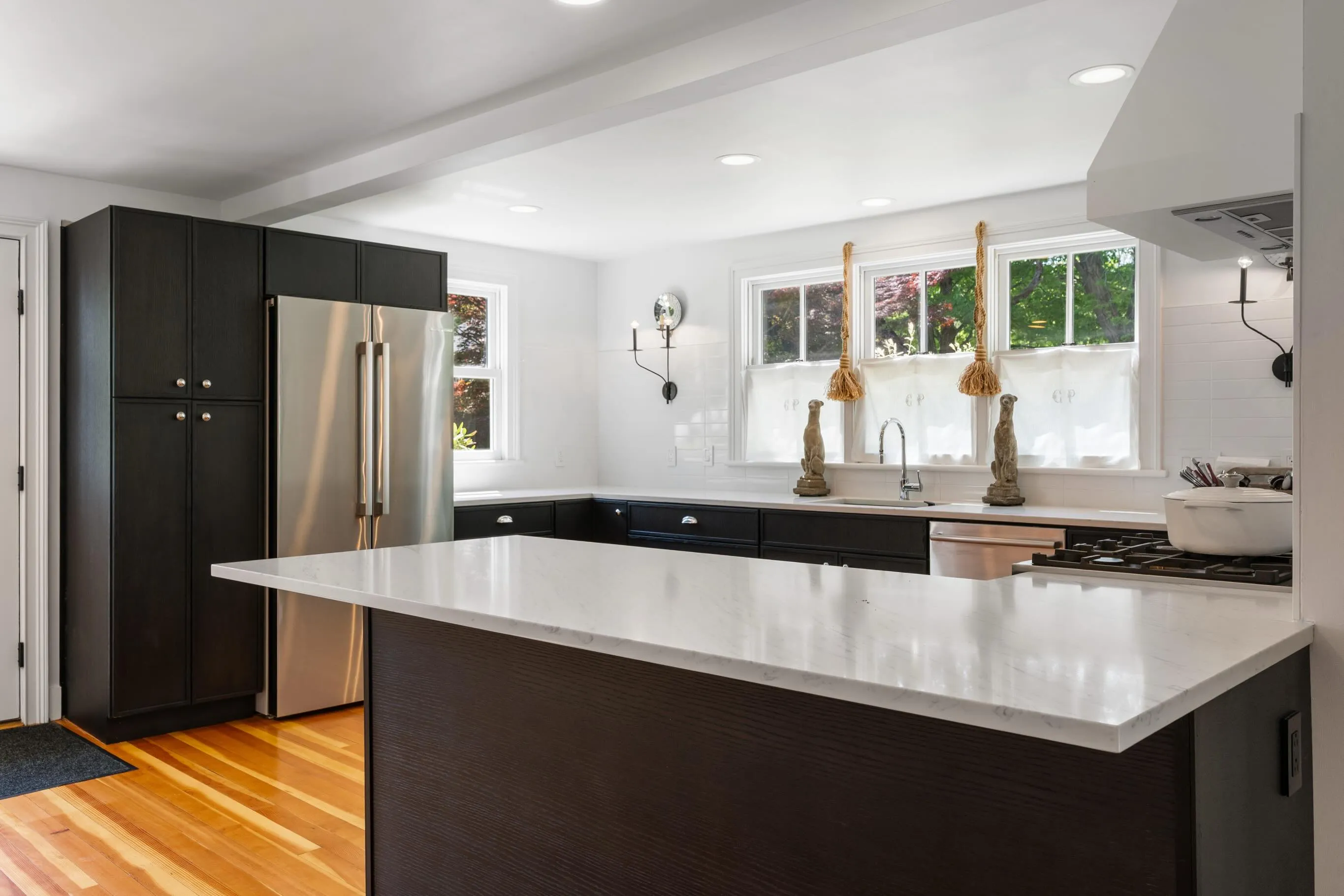 Black and white kitchen with ebonized island and heart pine floors
