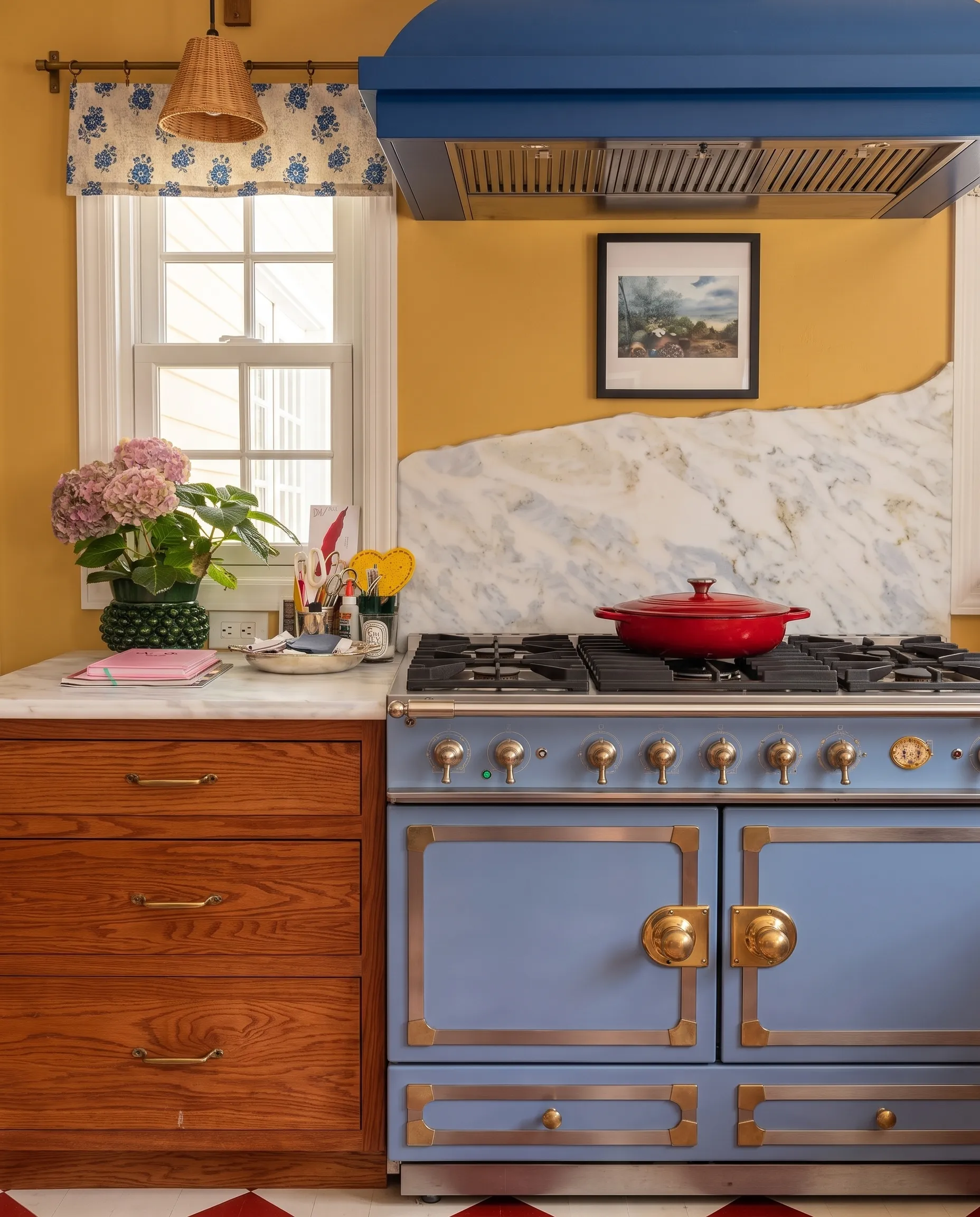 Hand-chiseled marble backsplash behind a cobalt French range