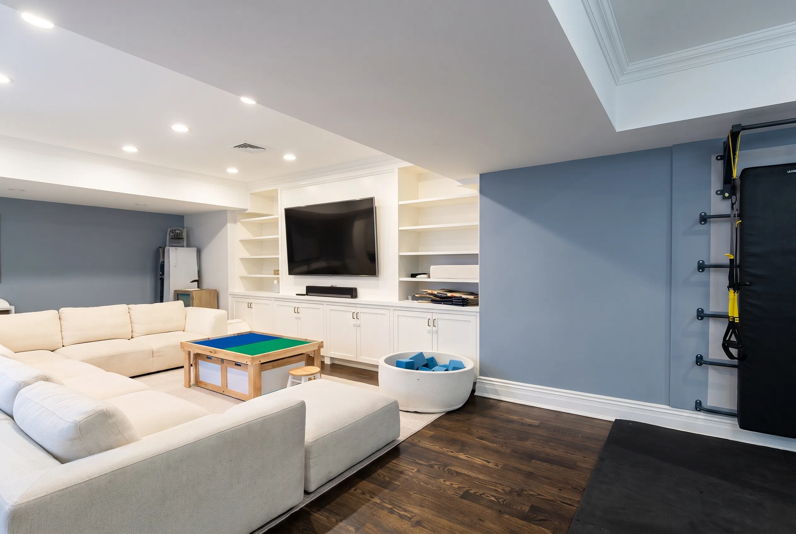 Sectional sofa and media wall in a finished family playroom