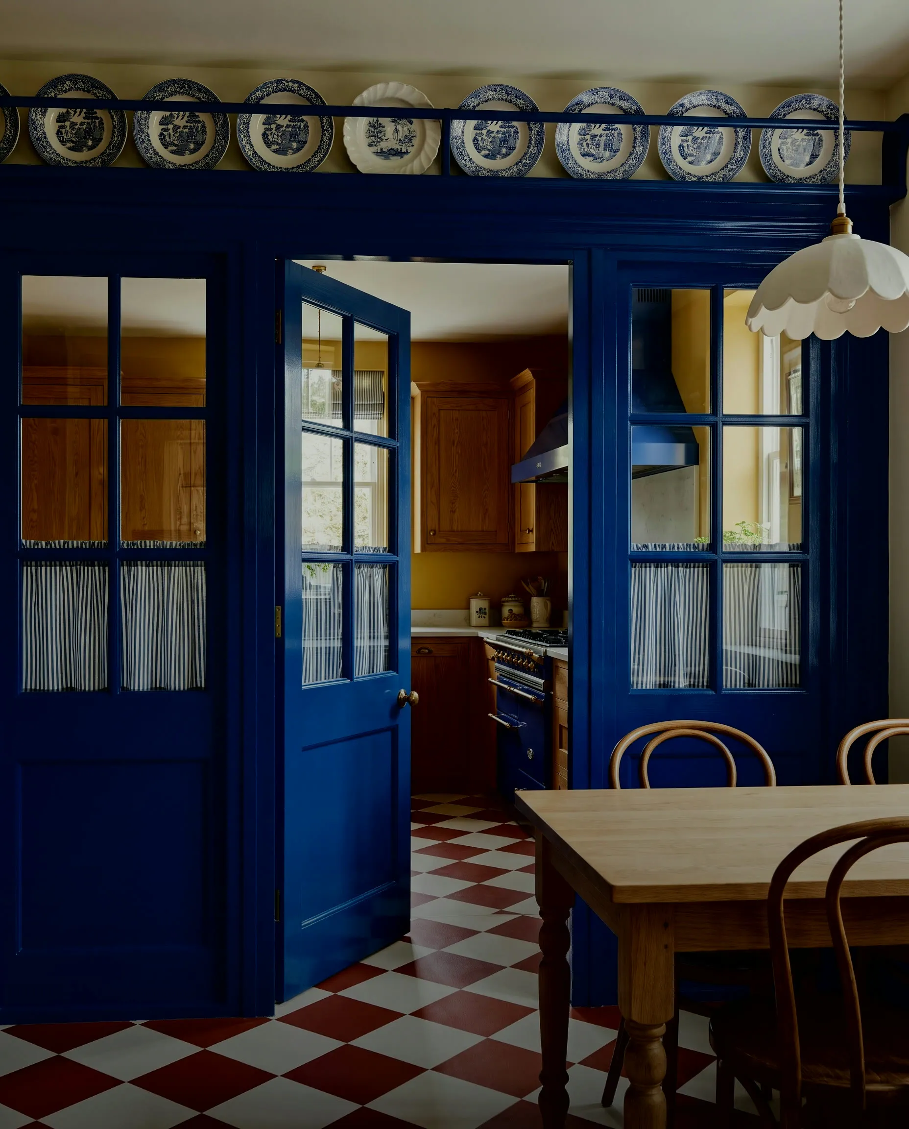 Blue-painted pantry doors in the mustard kitchen