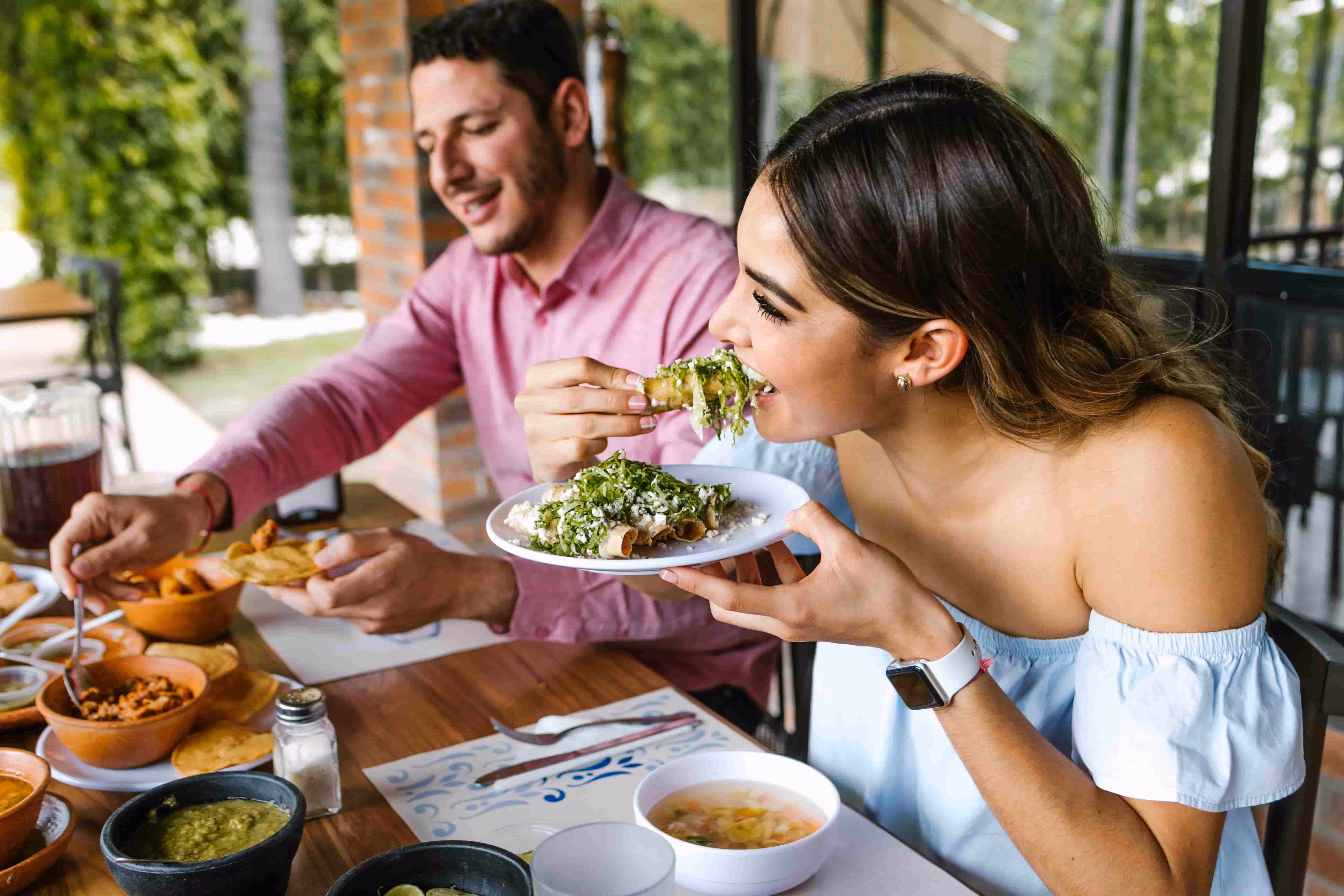 Couple enjoying a meal together at an outdoor restaurant.