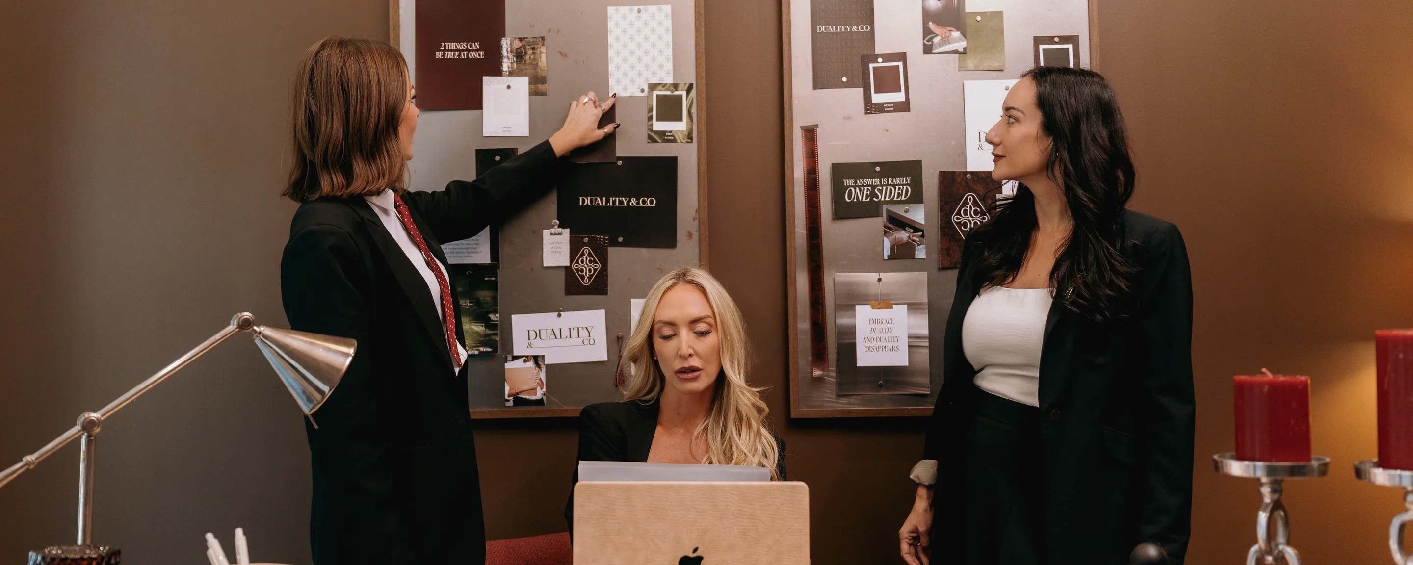 Kaylin Harding, Sara Gullickson and Jaclyn Freedman at work in front of their moodboards.