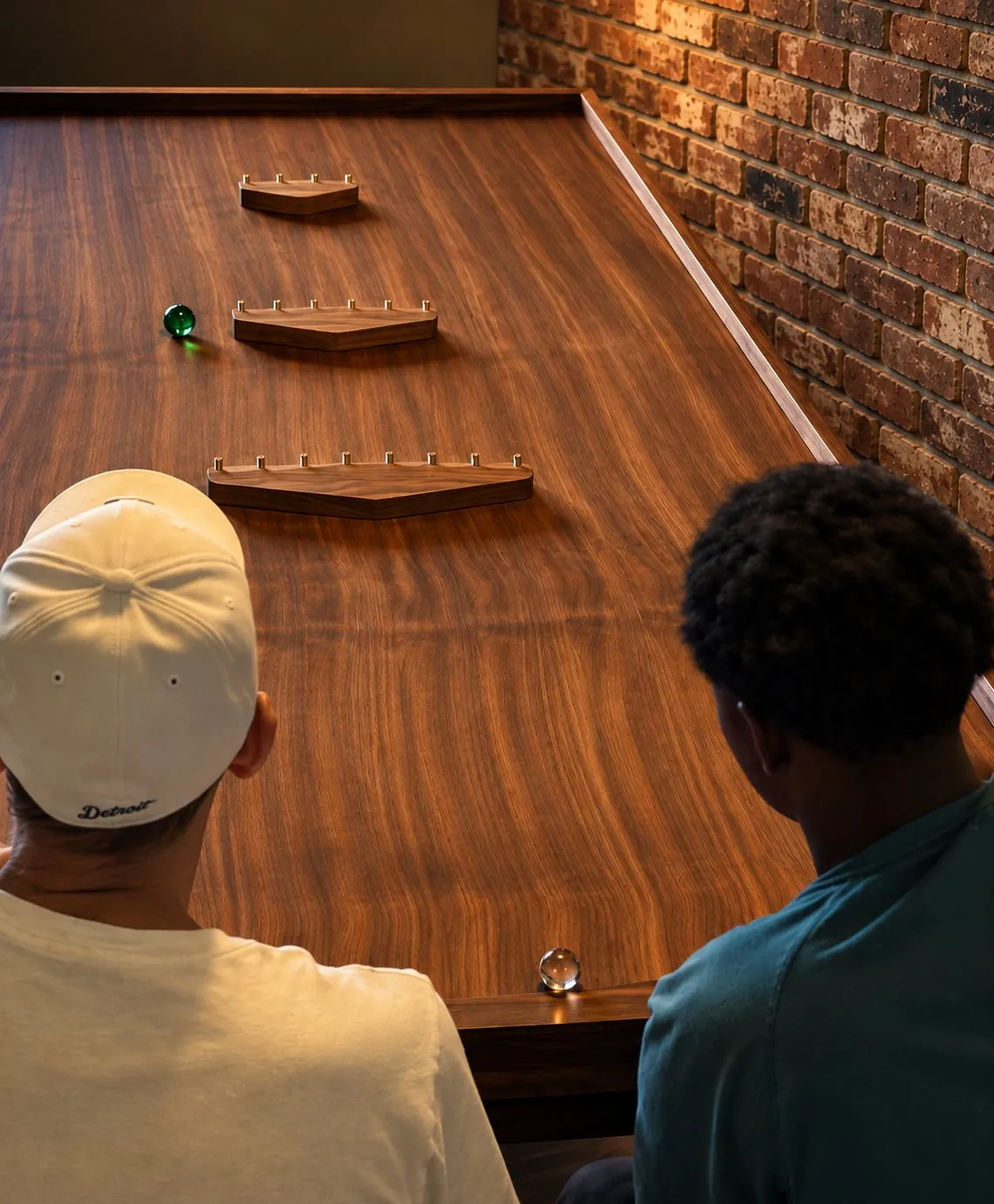 Two players at a Vortex468 walnut game table