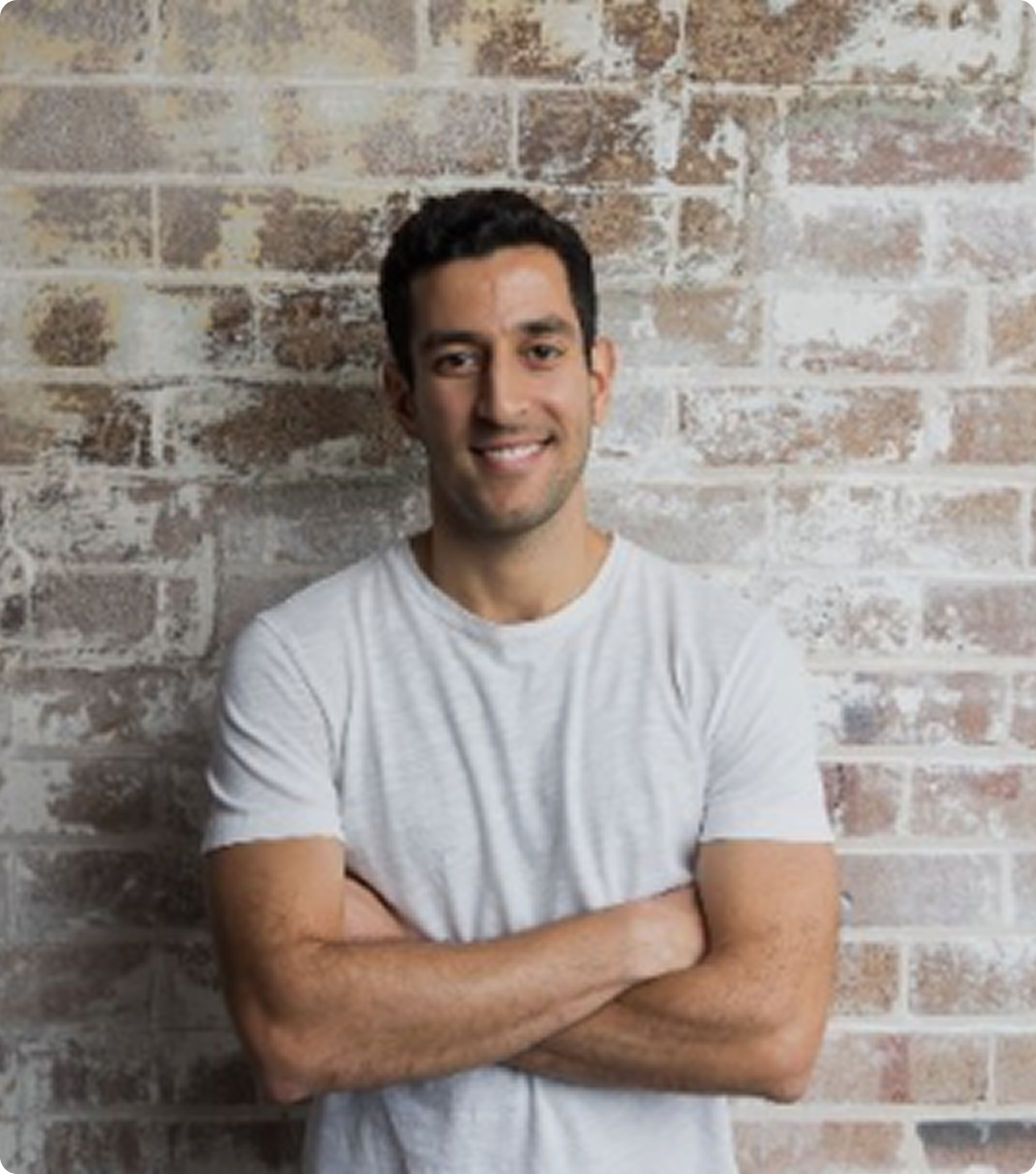Dan, a Blossom customer from Sydney, standing in front of a brick wall