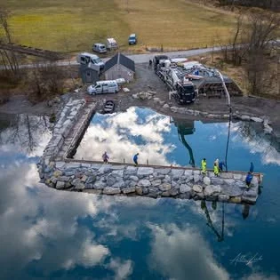 Oversiktsbilde av betongarbeid ved sjøen med pumpebil og forskaling