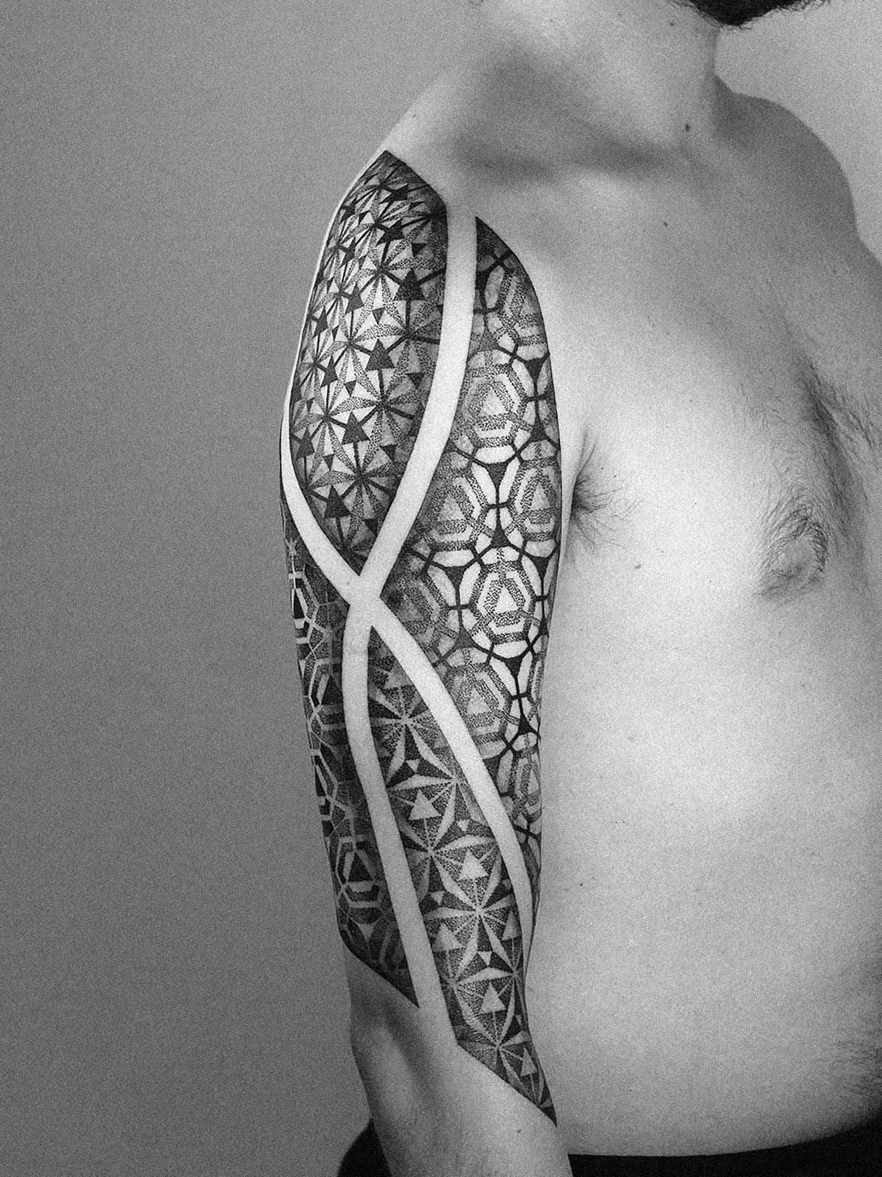 Tatuaż geometryczny na ramieniu męskim, precyzyjne wykonanie, patterny i linie z freehandu. Dotwork, autor - Paweł Kurylak | Zdjęcie wykonane w studio tatuażu w Gdańsku