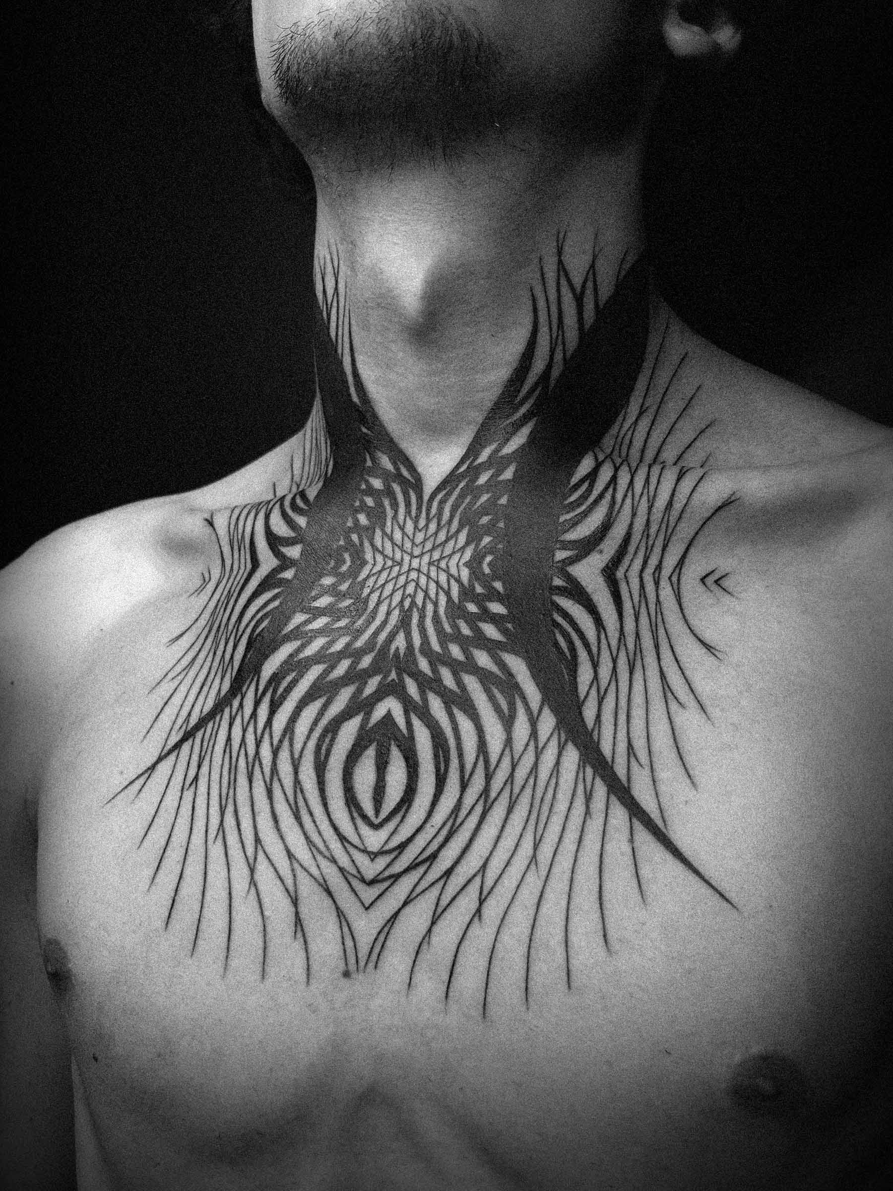 Abstract-geometric blackwork tattoo on a man's neck, chest and collarbones. Original design by Paweł Kurylak | Photo taken at a tattoo studio in Gdańsk.
