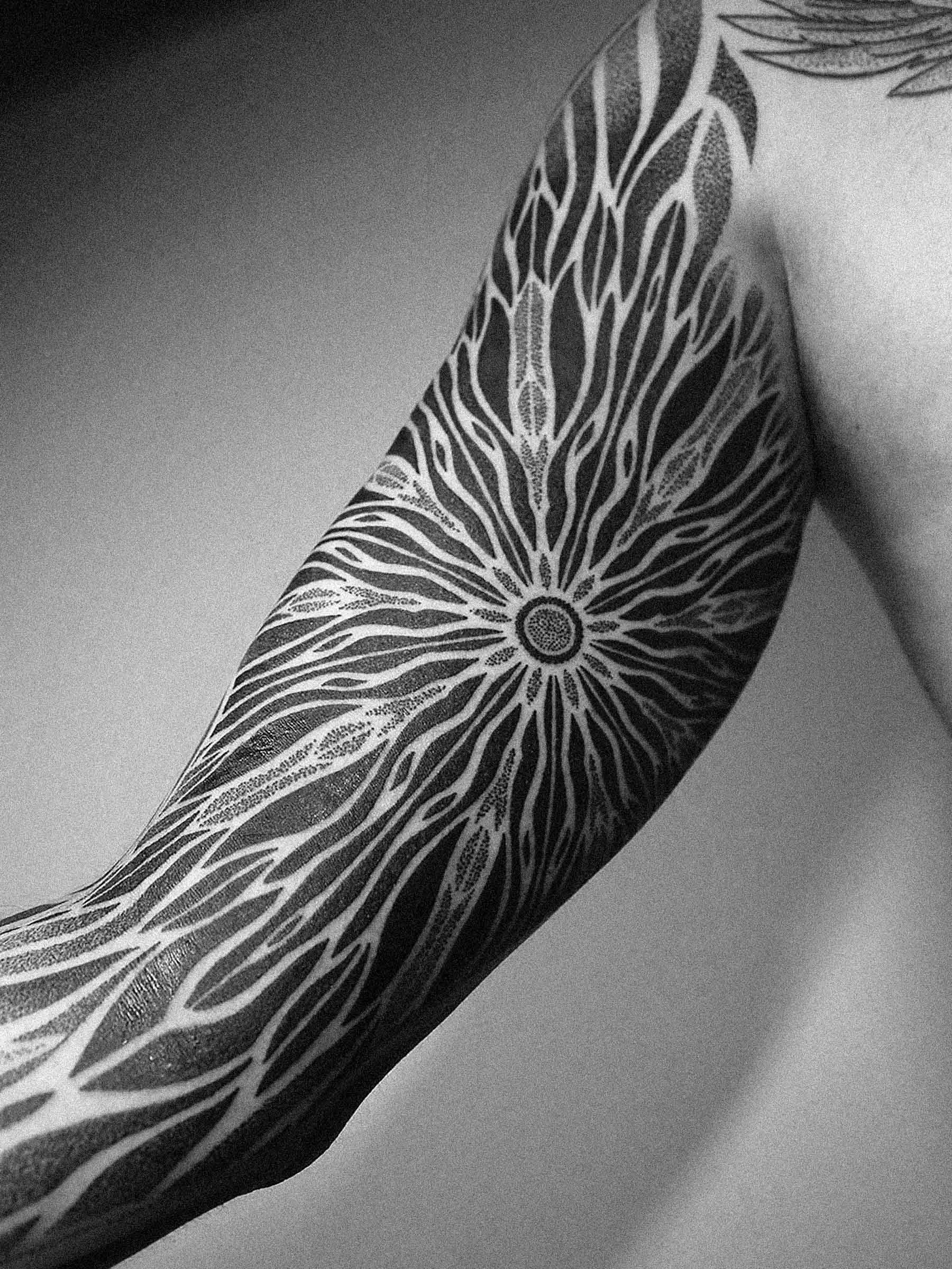 Tatuaż geometryczny, mandala na męskim ramieniu na wewnętrznej części bicepsa i ramieniu. Dotwork wykonał Paweł Kurylak | Zdjęcie zrobiono w studio tatuażu w Gdańsku
