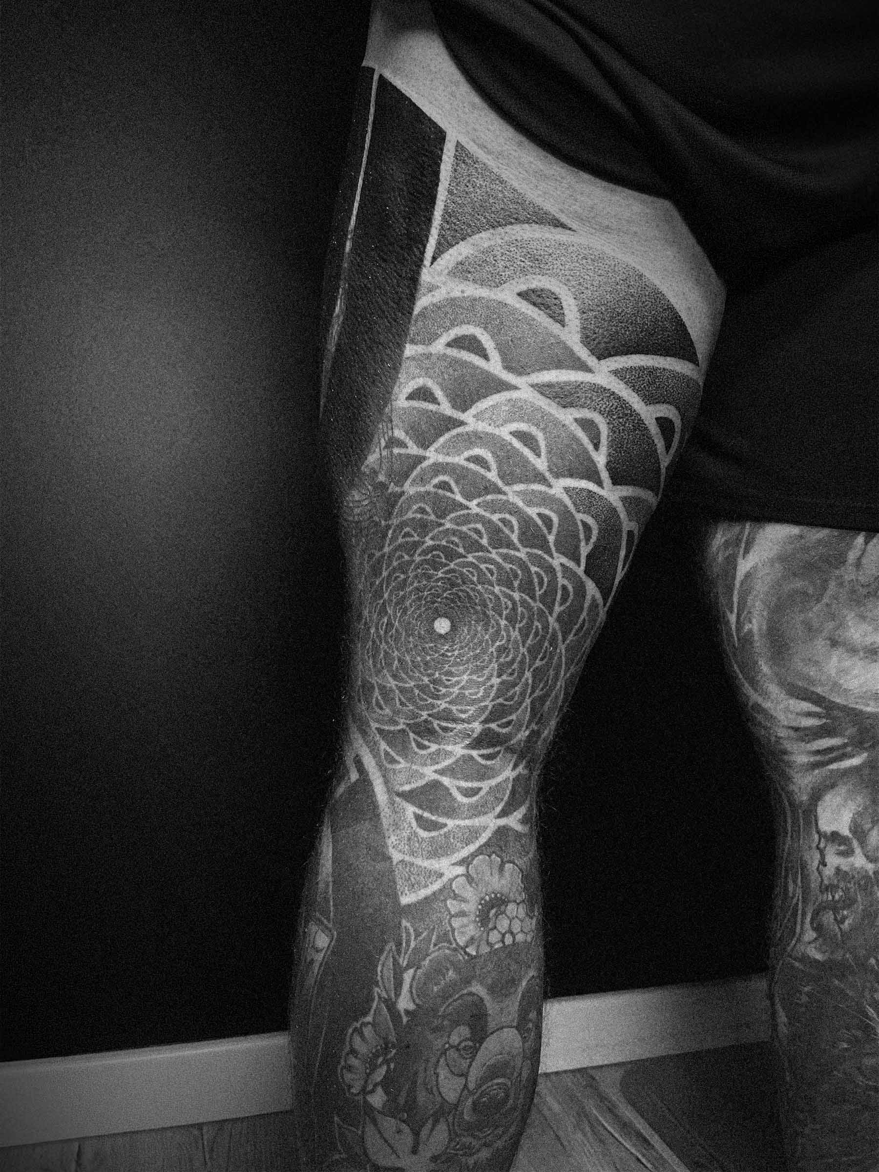 Geometric blackwork and dotwork tattoo on a man’s thigh featuring a spiral fractal pattern. Paweł Kurylak — geometric tattoo Gdańsk | Photo taken at a tattoo studio in Gdańsk