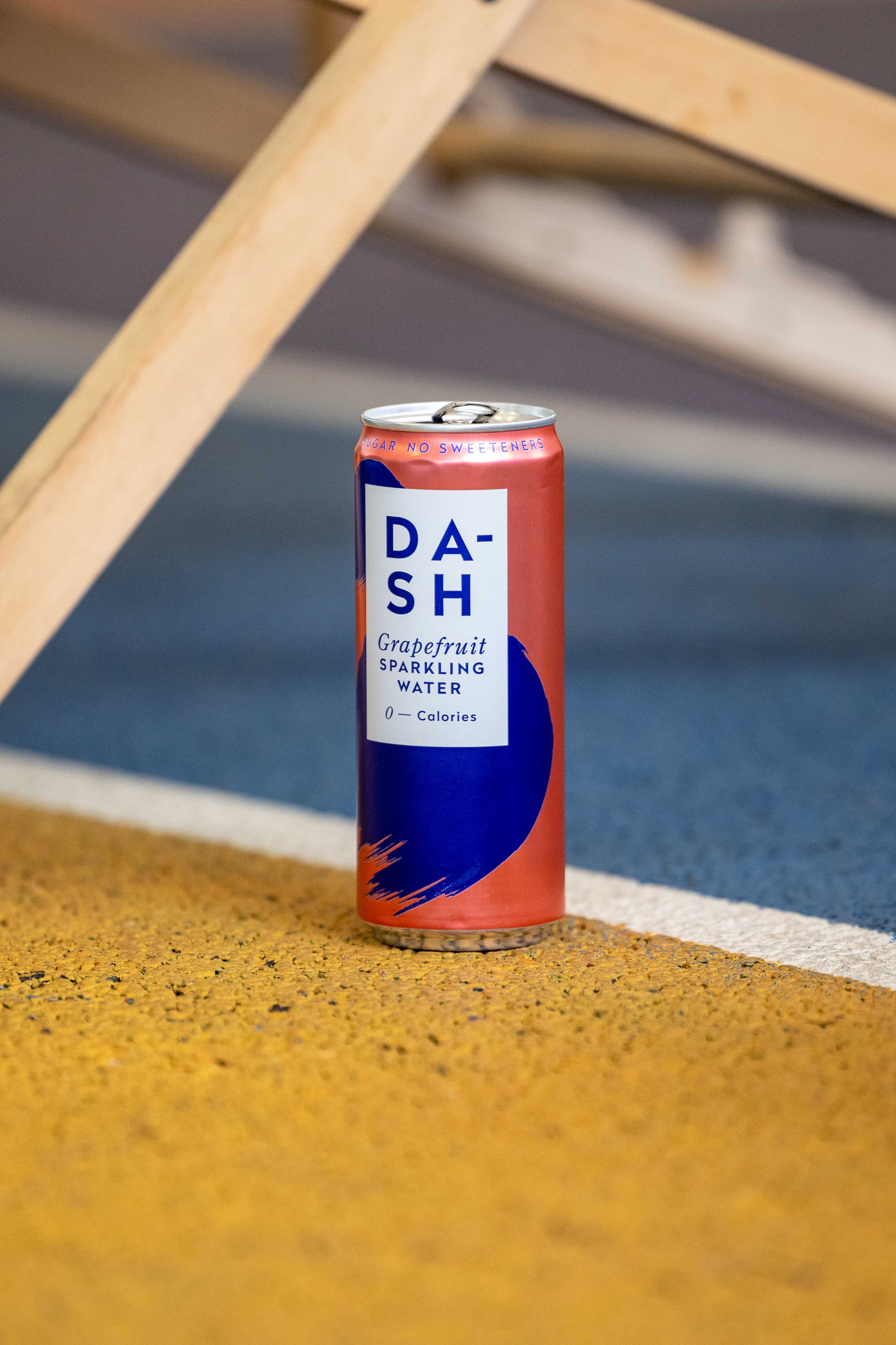 Dash sparkling water can photographed on a padel court