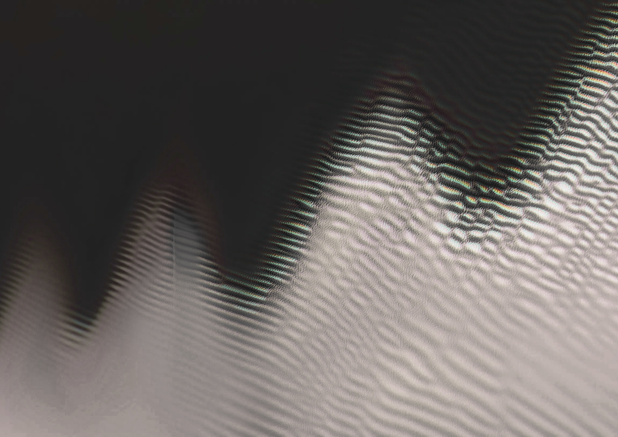 Close-up of a digital screen displaying a wavy, distorted blue and black pattern with visible pixel interference.