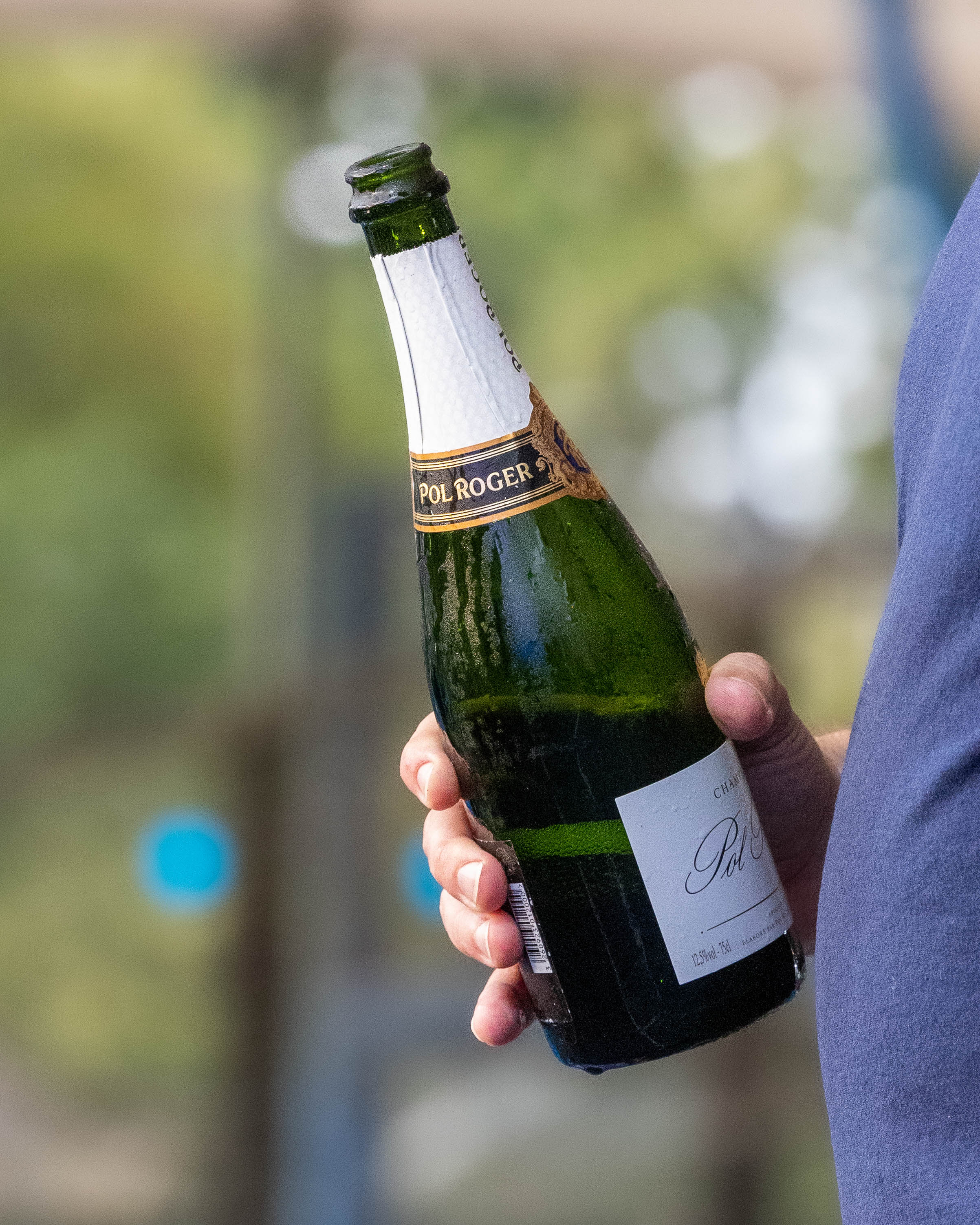 Pol Roger champagne bottle held at an outdoor event