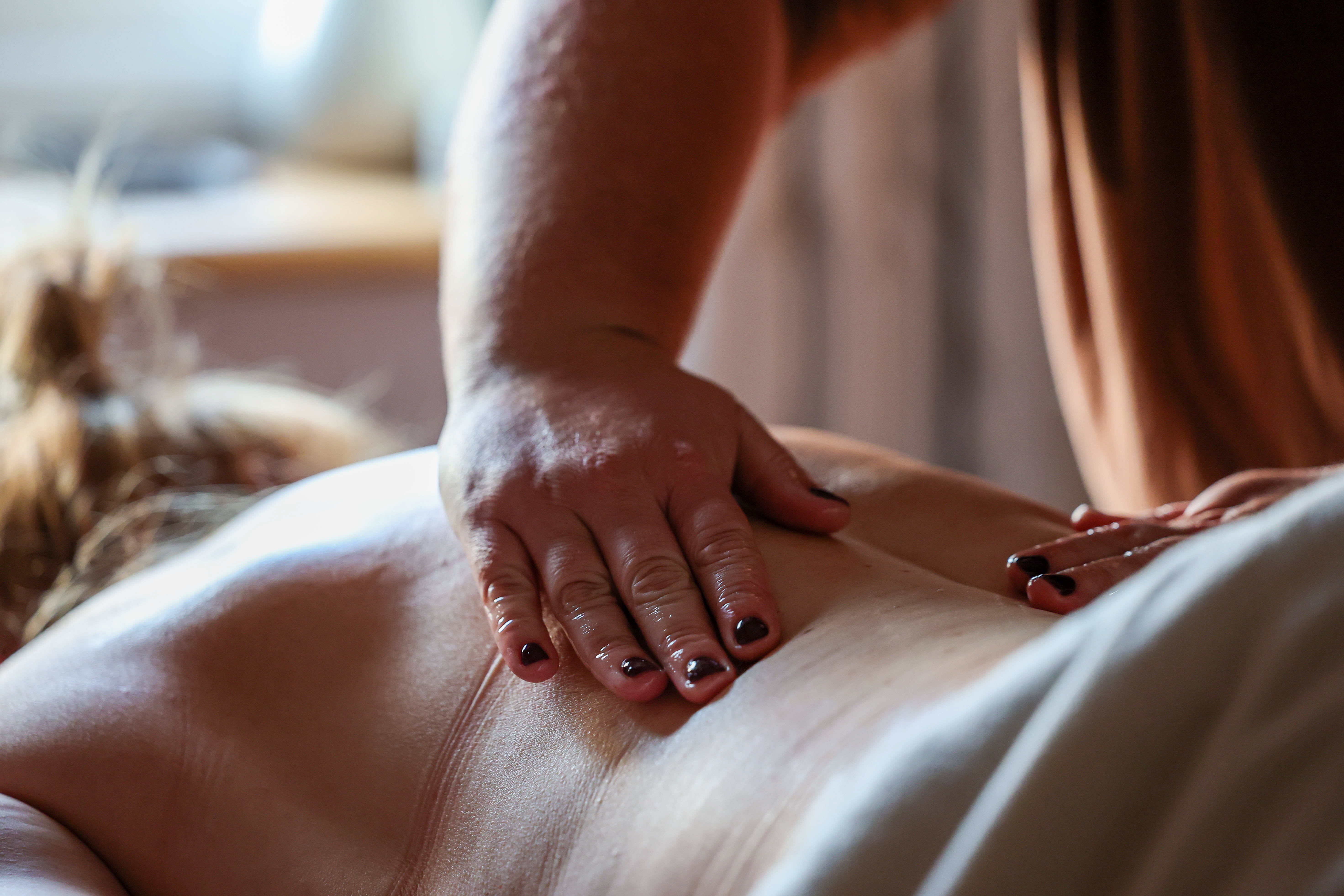 Massage therapist providing a back massage
