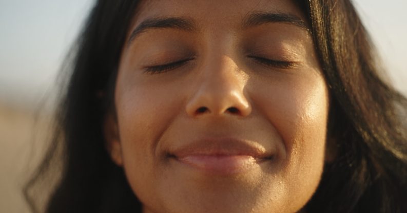 A guest smiling in warm daylight after a session.