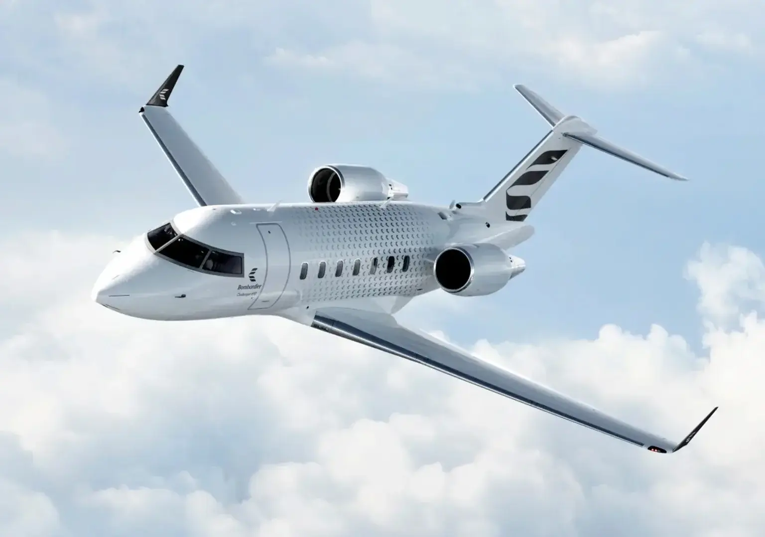 Bombardier Challenger business jet in flight above the clouds