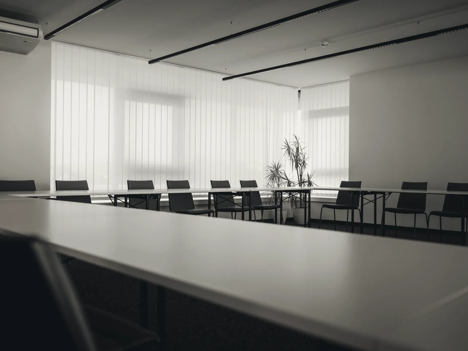 An empty boardroom with a long table, lit from one side
